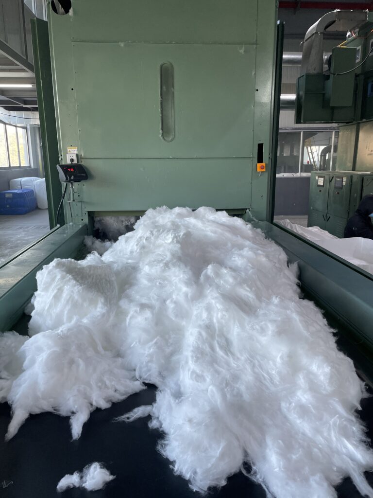 A close-up photo of loose, white polyester staple fibers
