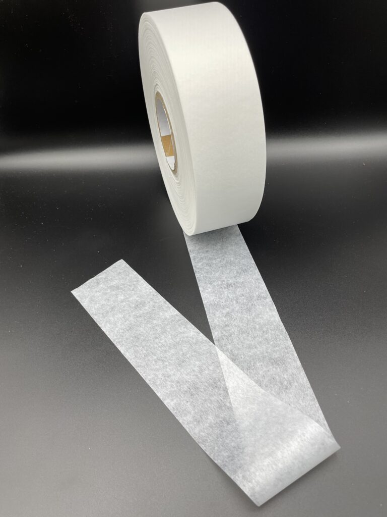 A roll of white polyester nonwoven fabric with a smooth, uniform surface
