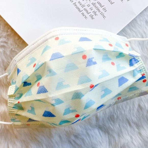 A green leaf emblem superimposed on a roll of PLA non-woven fabric