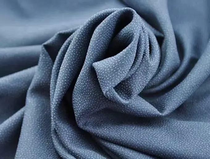 An example of a soft, flexible garment interlining made from non-woven fabric, draped over a hand