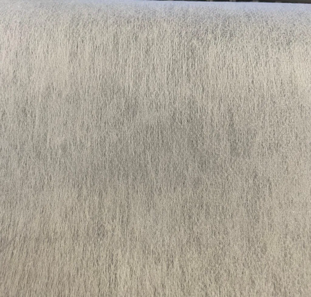 A magnified view showing the smooth, uniform surface of a thermally-bonded non-woven fabric