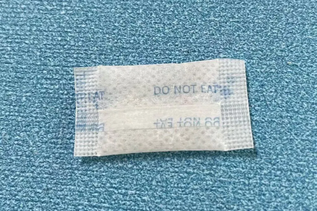 A close-up of a printed, sealed non-woven desiccant packet showing the texture and seal quality